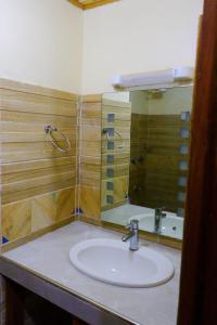 y baño con lavabo y espejo. en Khalisee Homes Studio apartment, en Voi