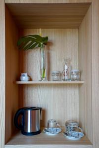 a shelf with a pot and glasses and a plant at Hotel La Briosa in Bolzano