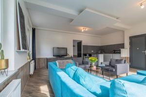 uma sala de estar com um sofá azul e uma televisão em Gemütliches Apartment in Neuwied em Neuwied