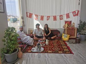 a group of people sitting on a couch in a living room at فندق المستقبل للشقق الفندقية ALMUSTAQBAL HOTEL Apartments in Ibrā