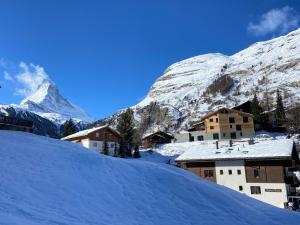 ein Dorf im Schnee mit einem Berg im Hintergrund in der Unterkunft Chalet Coral und Zermatter Stadel mit Sauna in Zermatt