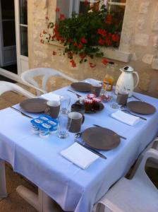 a table with a blue table cloth and plates on it at Gîte Les Rainettes in Coye-la-Forêt