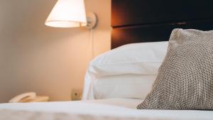 a bedroom with a bed with a pillow and a lamp at Vértice Sevilla Aljarafe in Bormujos