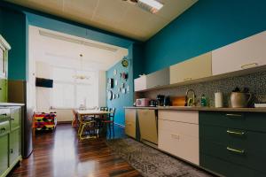 une cuisine aux murs bleus et une table avec des chaises dans l'établissement LaLeLu Hostel Dresden, à Dresde