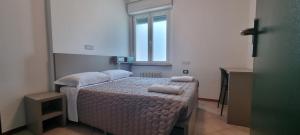 1 dormitorio con 1 cama con 2 almohadas en Ostello Giovane Europa di Trento, en Trento