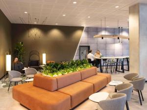 een lobby met een bank en stoelen en een bar bij Novotel Liverpool Paddington Village in Liverpool