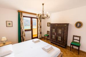 a bedroom with a bed and a chair and a window at Arzenhof, Baron Di Pauli in Caldaro