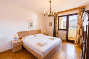 a bedroom with a bed and a large window at Arzenhof, Baron Di Pauli in Caldaro