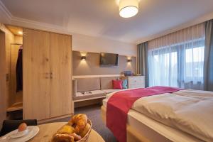 a hotel room with a bed and a table with a basket of bread at Appartementhaus Absmeier in Bad Füssing