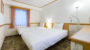 Ένα ή περισσότερα κρεβάτια σε δωμάτιο στο Toyoko Inn Fukuyama-eki Shinkansen Minami-guchi