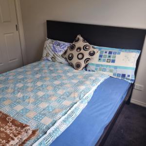 a bed with a blue quilt and pillows on it at Home stay in Wyndham Vale