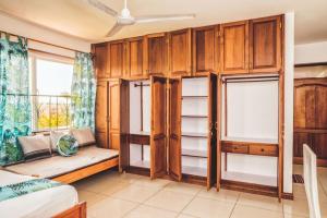 1 dormitorio con armarios de madera, 1 cama y ventana en NEW BEACHFRONT HOMESTAY, en Mombasa