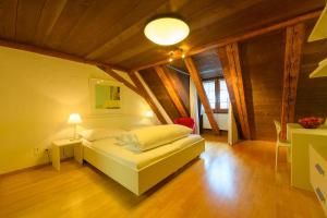 a bedroom with a bed and a table and a lamp at Landhotel Linde Fislisbach in Baden