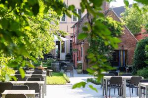 een rij tafels en stoelen op een binnenplaats bij Boutique hotel Sies in Watervliet