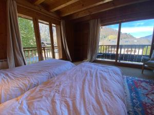 1 Schlafzimmer mit 2 Betten und einem großen Fenster in der Unterkunft Chalet Savoyard avec Cheminée et Parking à Samoëns - FR-1-624-80 in Samoëns