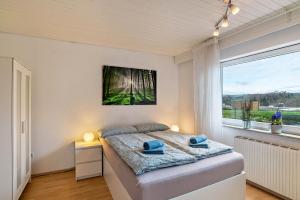 a bedroom with a bed and a large window at Wächtersberg in Wildberg