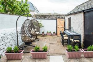 een patio met een tafel en potplanten erop bij Lavender Terrace in Llandudno