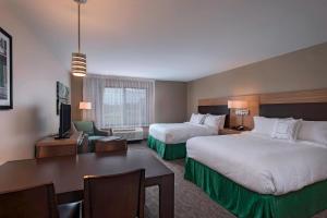 TownePlace Suites by Marriott Slidell في سليدل: غرفة فندقية بسريرين ومكتب