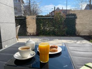 a table with a cup of coffee and a cup of orange juice at Spa Residence Carbona Royal Suites 1.11 in Hévíz