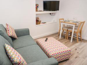 a living room with a couch and a table at Tŷ Capel Bach in Bangor