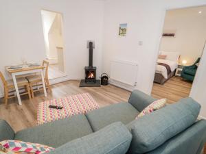 a living room with a couch and a fire place at Tŷ Capel Bach in Bangor