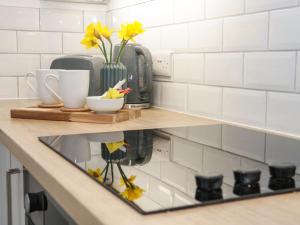 a kitchen counter with yellow flowers on a counter top at Tŷ Capel Bach in Bangor