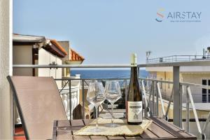 eine Flasche Wein und zwei Weingläser auf dem Balkon in der Unterkunft Nautilus Apartments Airport by Airstay in Artemida