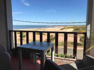 een tafel op een balkon met uitzicht op de oceaan bij El Diablo Chic Colonial in Punta Del Diablo