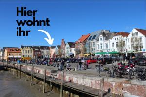 uma cidade com um sinal que diz que vale a pena em smør I Skandi-Style im Speicher I 1 Min zum Hafen em Husum