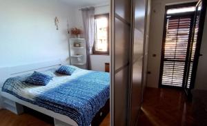 a bedroom with a bed with blue sheets and a window at Apartmaji Ri-100 in Portorož