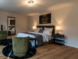 a bedroom with a large bed and a chair at Suite Home Apartments in Weimar