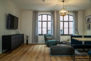 a living room with a couch and chairs and a tv at Suite Home Apartments in Weimar