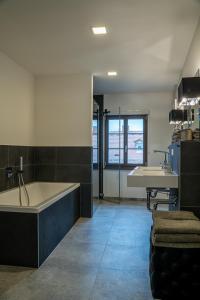 a large bathroom with a tub and a sink at Suite Home Apartments in Weimar