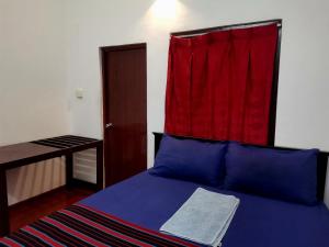 een slaapkamer met een bed met een rood gordijn erboven bij Nallur Holidays Inn in Jaffna