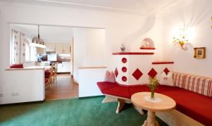 sala de estar con sofá rojo y mesa en Ferienschlössl Harmonie, en Holzgau