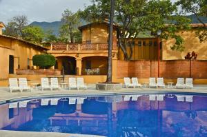 una piscina con sedie bianche e una casa di Villas Danza del Sol a Ajijic