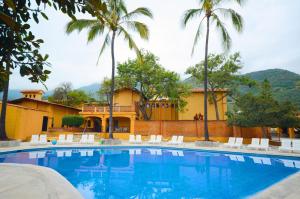 una piscina di fronte a una casa con palme di Villas Danza del Sol a Ajijic