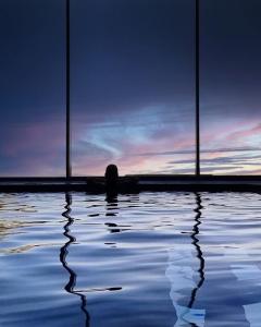 eine Person sitzt in einem Pool aus Wasser in der Unterkunft Albergo Moderno & Spa in Fuipiano Valle Imagna