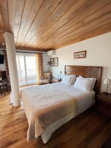 a bedroom with a large bed with a wooden ceiling at Casa De Canilhas in Mesão Frio