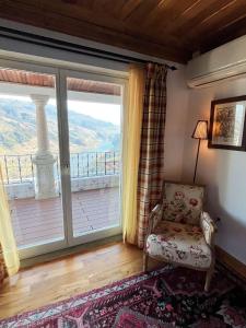 a living room with a chair and a large window at Casa De Canilhas in Mesão Frio