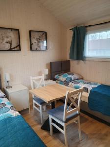 een kamer met 2 bedden en een tafel en stoelen bij Pokoje Babie Lato in Wrocław