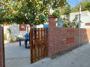 una valla de ladrillo con una puerta de madera y un árbol en Homestay Miền Biển Vĩnh Hy 2, en Vĩnh Hy