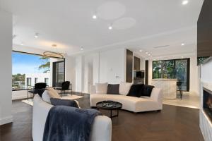 sala de estar con muebles blancos y chimenea en Luxury Waterside Home Sanctuary, en Sídney