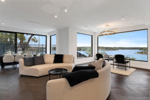 una sala de estar con sofás y vistas al agua. en Luxury Waterside Home Sanctuary, en Sídney