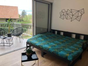 een bed in een kamer met een balkon bij Studio Moderne, Terrasse et Parking in Romans-sur-Isère