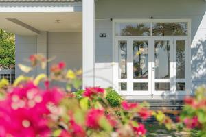 eine Haustür eines Hauses mit rosa Blumen in der Unterkunft Casa Villa - Ocean View - Sealinks City Resort in Phan Thiet