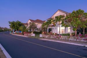 ein Haus mit einem Zaun am Straßenrand in der Unterkunft Casa Villa - Ocean View - Sealinks City Resort in Phan Thiet