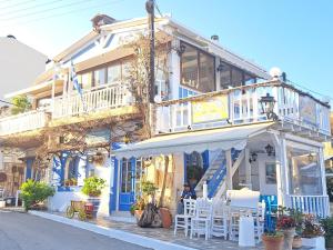 un bâtiment avec des finitions blanches et bleues, des tables et des chaises dans l'établissement Stella Apartments Malia, à Mália