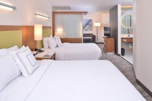 ein Hotelzimmer mit 2 Betten und einem TV in der Unterkunft SpringHill Suites Las Vegas Henderson in Las Vegas