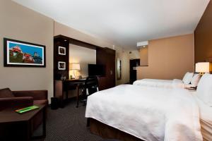 a hotel room with two beds and a desk at Courtyard by Marriott Montreal Downtown in Montréal